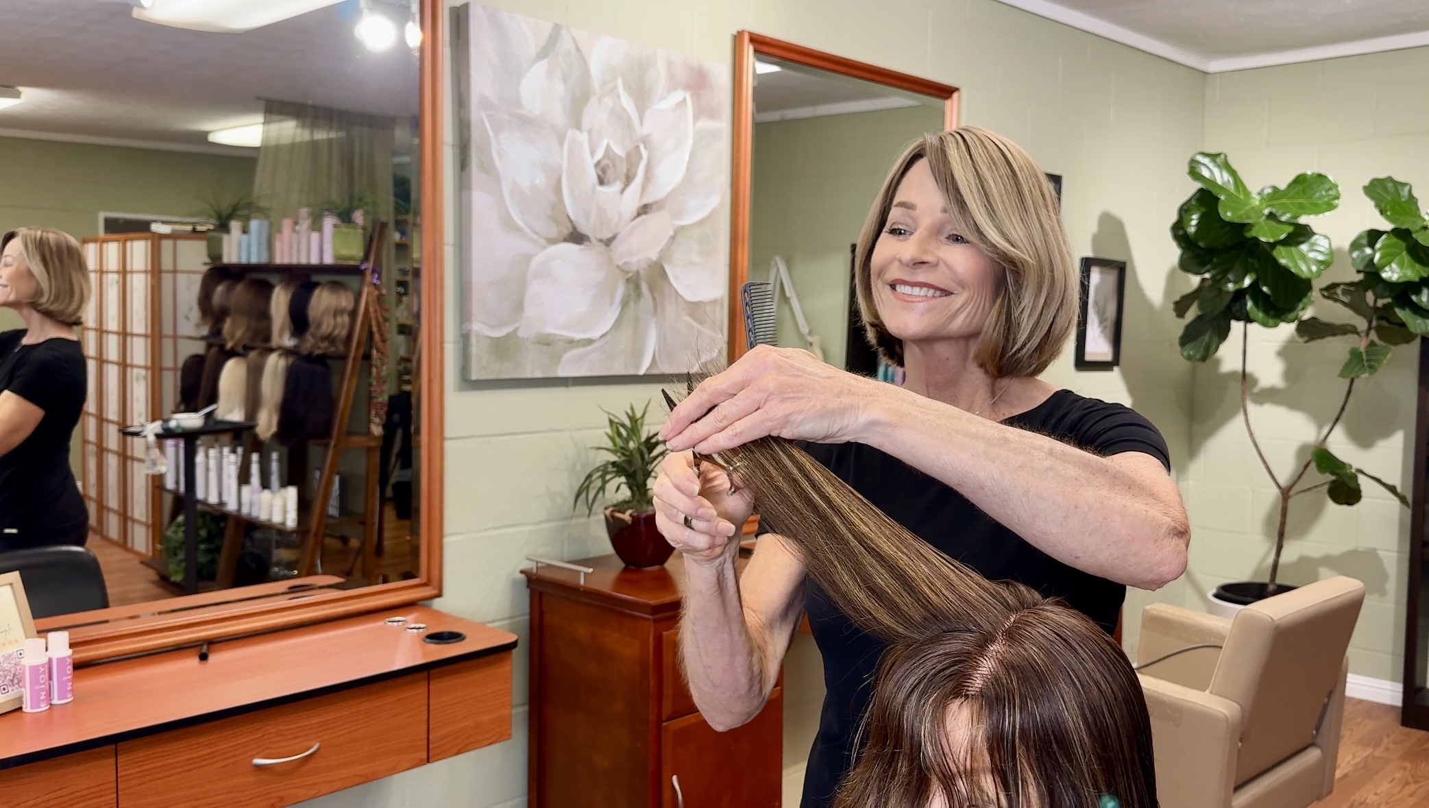 Image of salon owner Lisa Shewman cutting a woman's hair