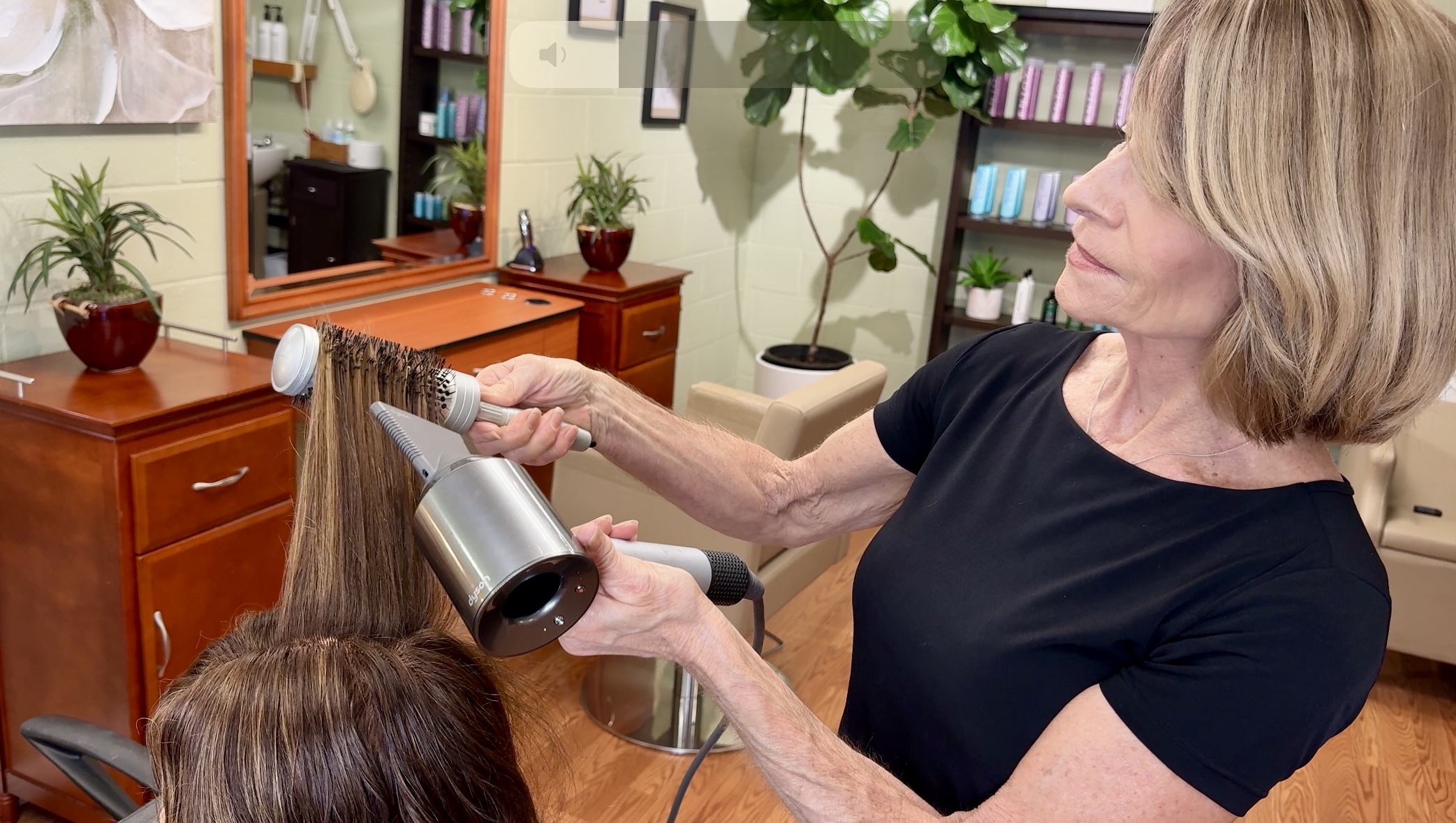 Image of salon owner Lisa Shewman blowdrying a woman's hair